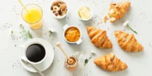 Frühstück mit Croissants, Kaffee, Orangensaft, Honig und weiteren Aufstrichen.